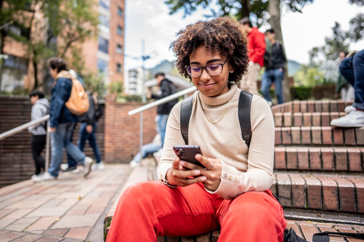 Teenager smiling at her phone.