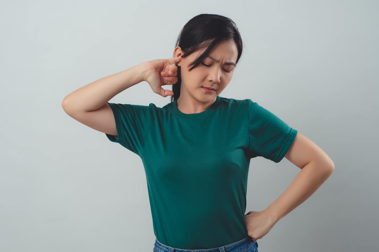 Woman with tinnitus holds ear
