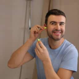 Man wears earplug to protect hearing