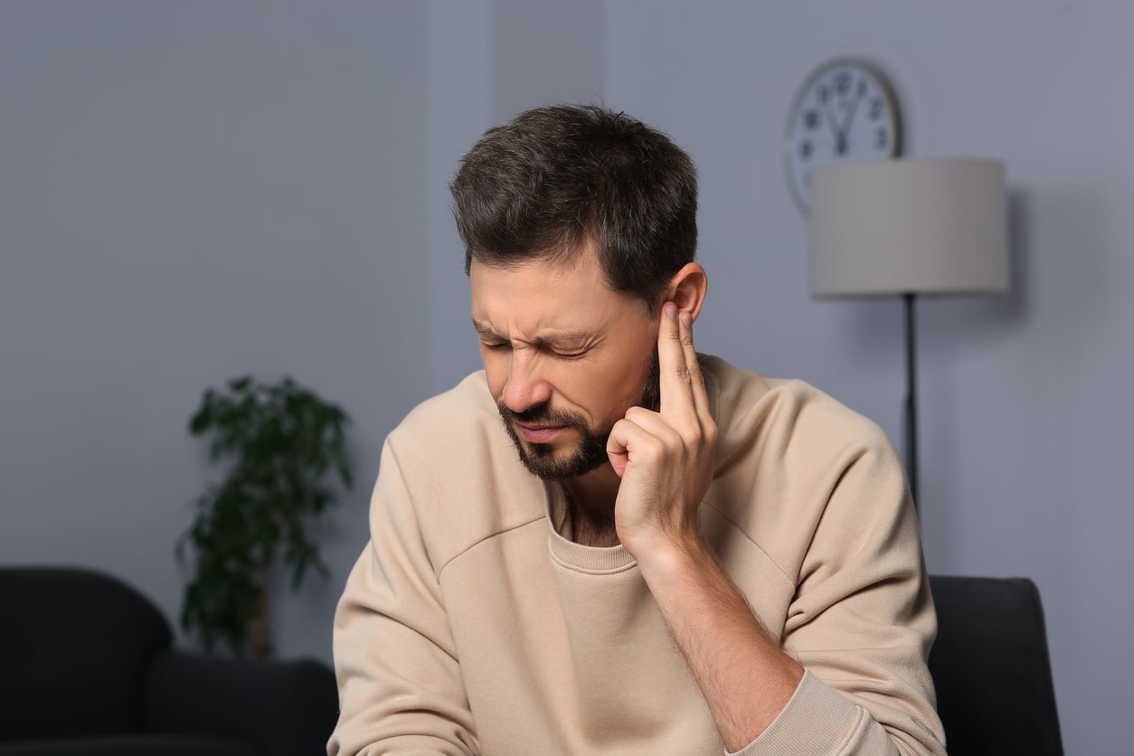 Man holding his ear experiencing misophonia