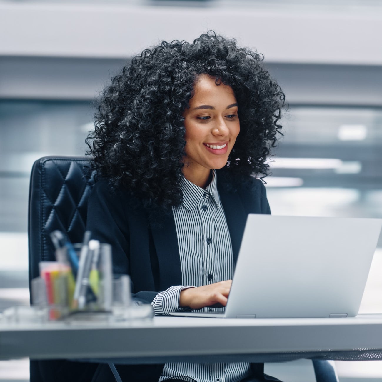 Woman at work smiling and managing her tinnitus.