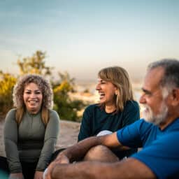 Group of friends chatting and laughing on the beach.