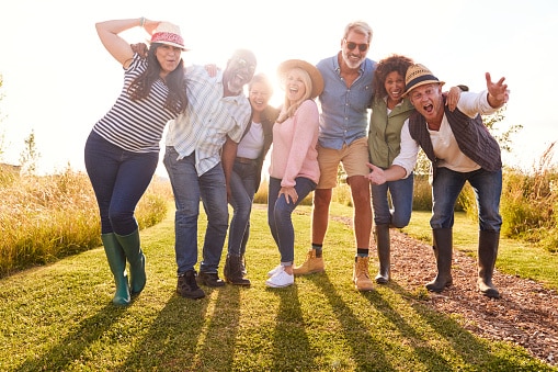 Big group of happy friends posing in a vineyard