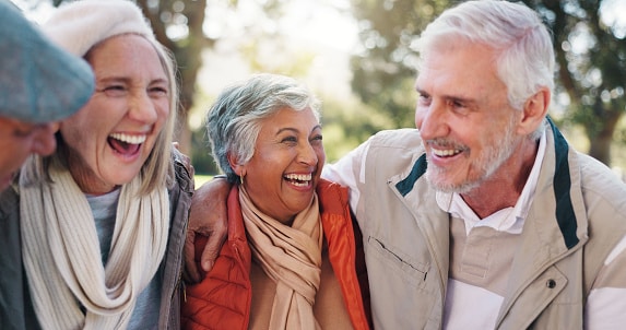 Group of friends laughing and hugging together.