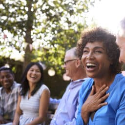 Group Of Mature Friends Socializing In Backyard Together