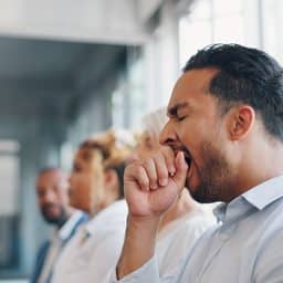 Tired, yawn and sleepless with a business man sitting in a meeting or presentation with his team for development.